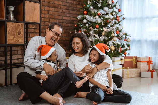 Famiglia felice asiatica che celebra il Natale insieme a casa