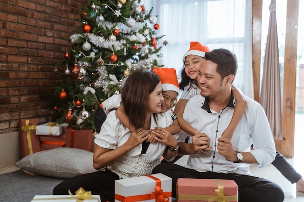 Famiglia felice asiatica che celebra il Natale insieme a casa