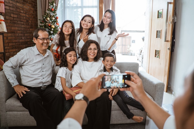 Famiglia felice asiatica che celebra il Natale insieme a casa