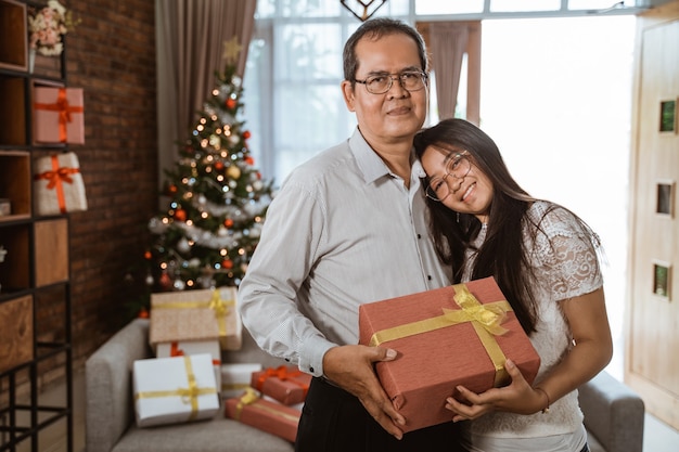 Famiglia felice asiatica che celebra il Natale insieme a casa