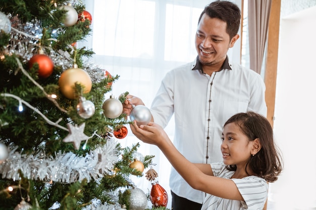 Famiglia felice asiatica che celebra il Natale insieme a casa