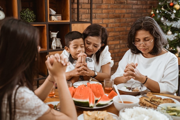 Famiglia felice asiatica che celebra il Natale insieme a casa