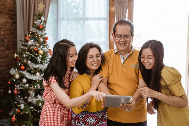 Famiglia felice asiatica che celebra il Natale insieme a casa