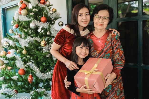 Famiglia felice asiatica che celebra il Natale insieme a casa