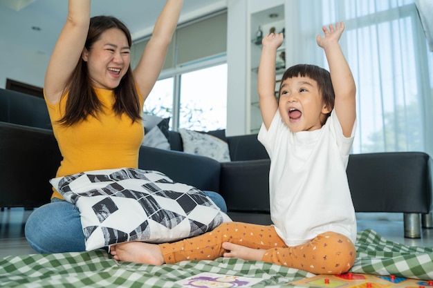 Famiglia felice Bambina che gioca a un giocattolo per lo sviluppo con la madre