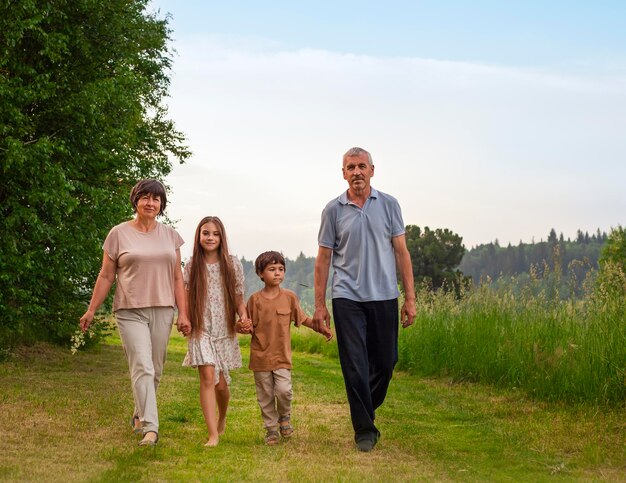 Famiglia felice cammina nel parco in un giorno d'estate nonno nonna e nipoti