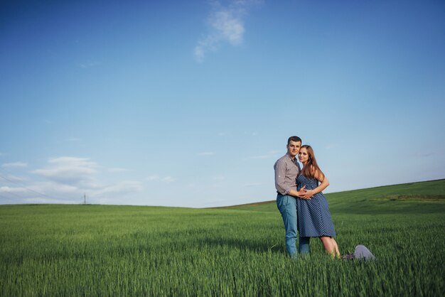 Famiglia felice che abbraccia in un campo di grano verde