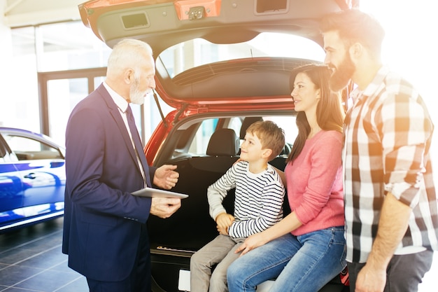 Famiglia felice che acquista una nuova auto presso l'autosalone.