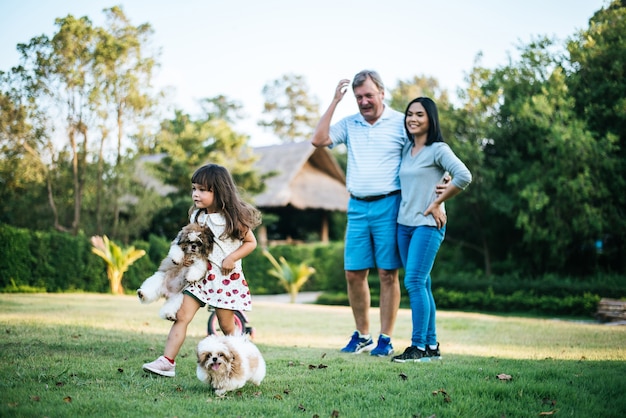 Famiglia felice che cammina con il cane nel parco