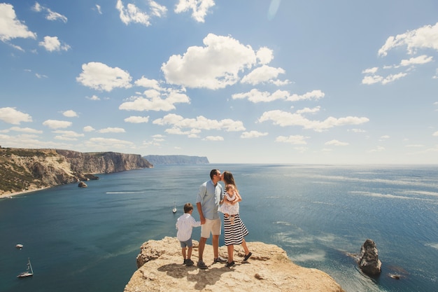 Famiglia felice che cammina in montagna sul mare