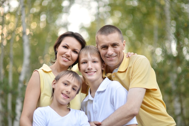 Famiglia felice che cammina in un bosco di betulle