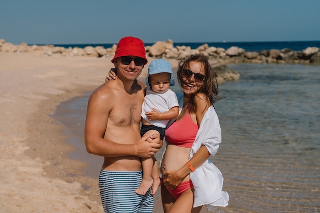 Famiglia felice che cammina su una spiaggia tenendosi per mano