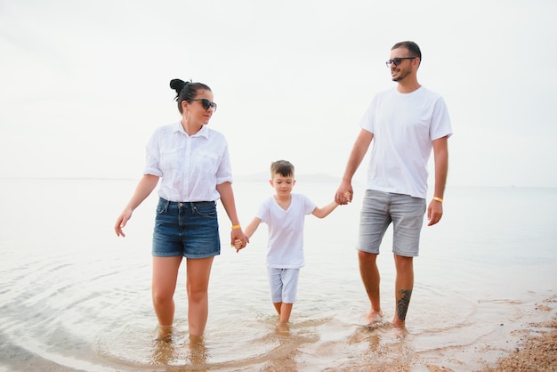 Famiglia felice che cammina sulla spiaggia