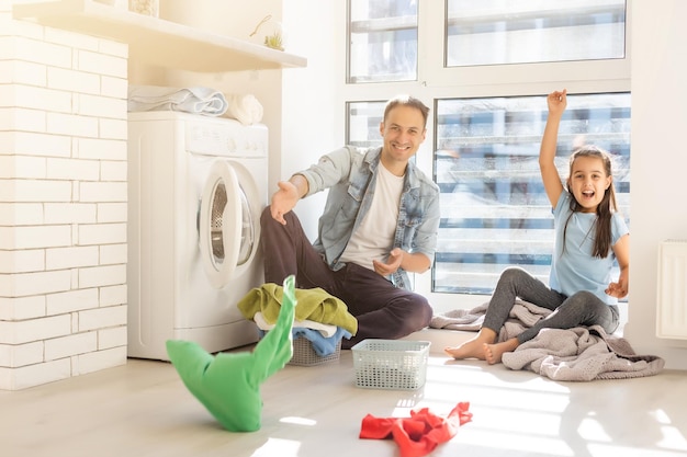 Famiglia felice che carica i vestiti nella lavatrice di casa