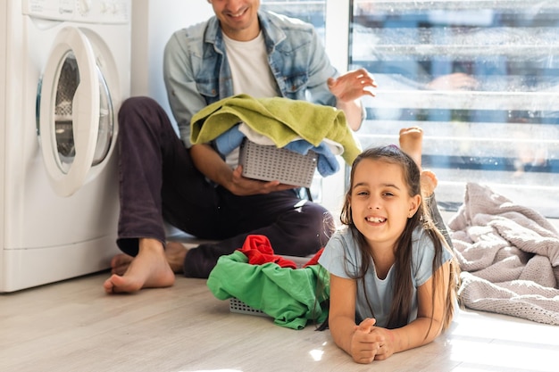 Famiglia felice che carica i vestiti nella lavatrice di casa