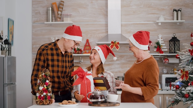 Famiglia felice che celebra la stagione invernale godendosi le vacanze di Natale in piedi al tavolo