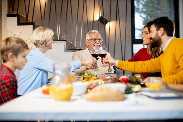 Famiglia felice che cena con vino rosso a casa