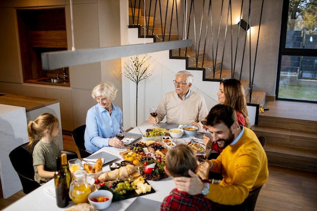 Famiglia felice che cena con vino rosso a casa