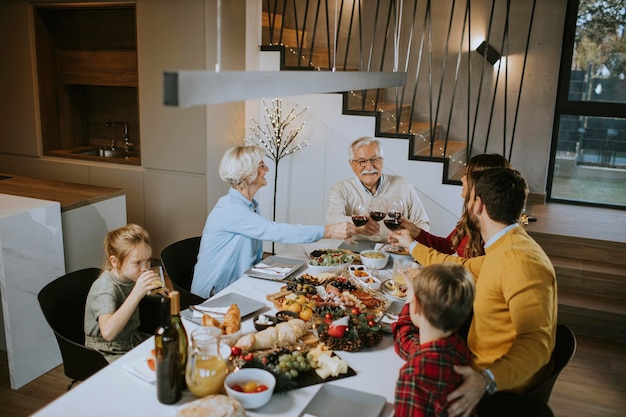 Famiglia felice che cena con vino rosso a casa