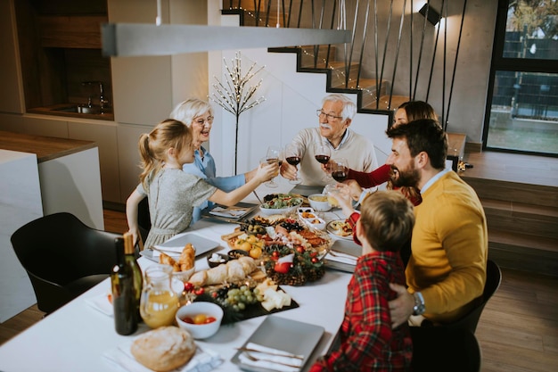 Famiglia felice che cena con vino rosso a casa