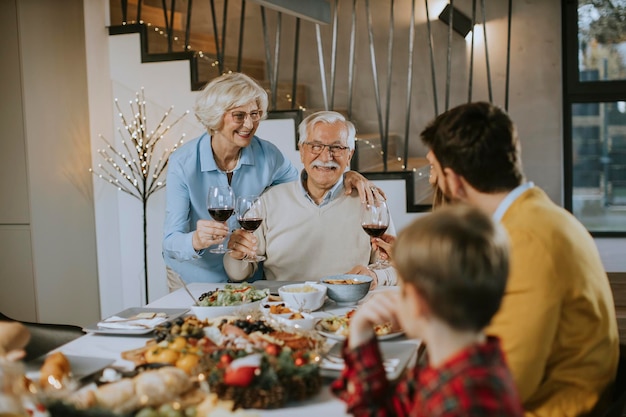 Famiglia felice che cena con vino rosso a casa