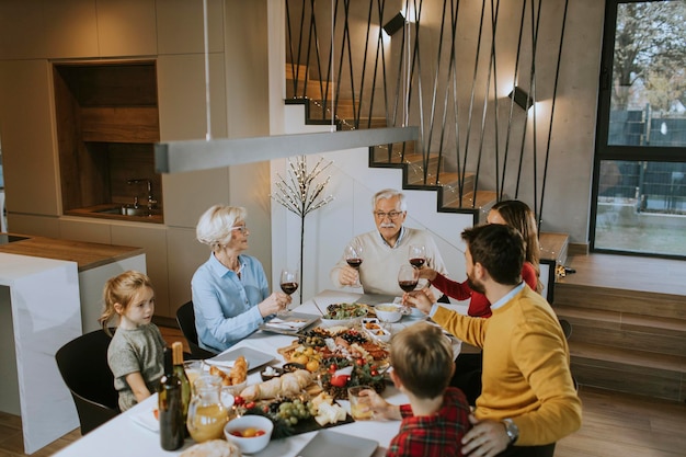 Famiglia felice che cena con vino rosso a casa