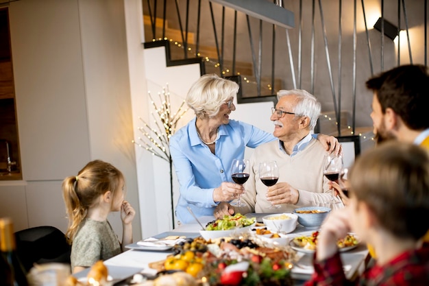 Famiglia felice che cena con vino rosso a casa