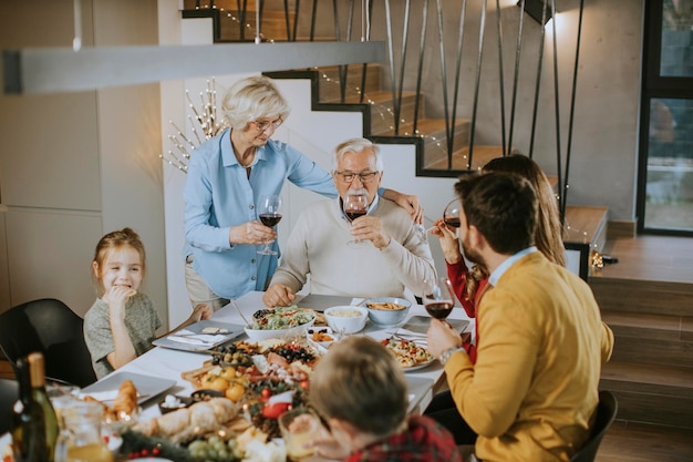 Famiglia felice che cena con vino rosso a casa