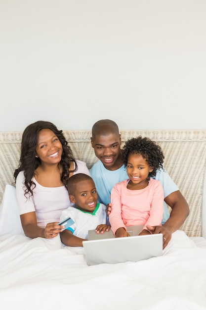 Famiglia felice che compera online con il computer portatile
