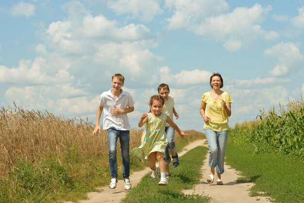 Famiglia felice che corre su una strada sterrata