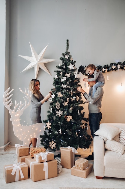 Famiglia felice che decora l'albero di Natale.