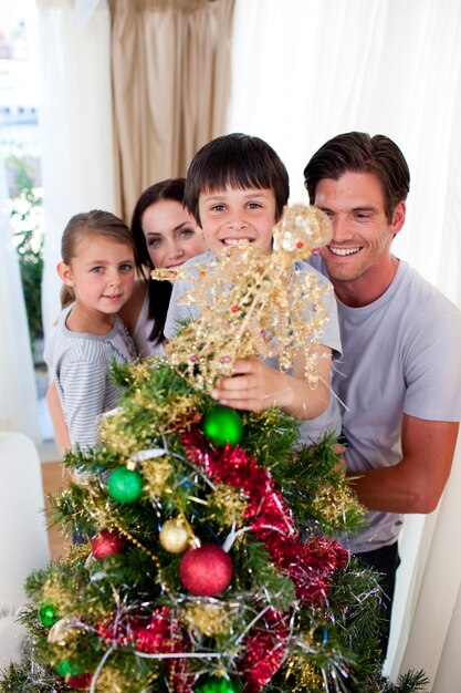 Famiglia felice che decora un albero di Natale