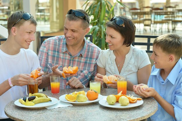 Famiglia felice che fa colazione insieme nella caffetteria all'aperto del resort