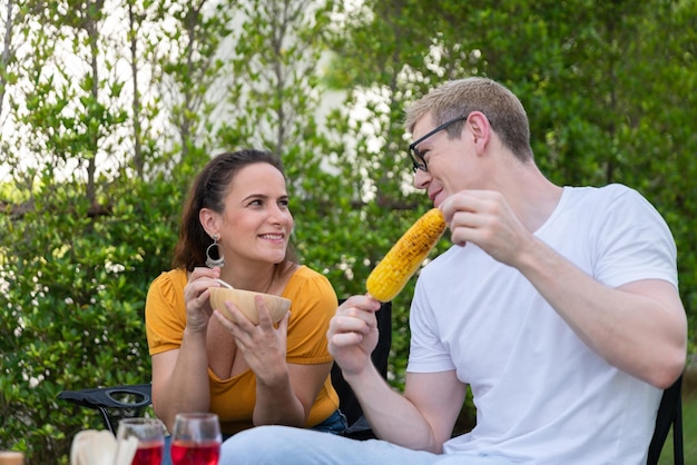 Famiglia felice che fa festa barbecue barbecue con vino rosso nel giardino esterno della casa con felice