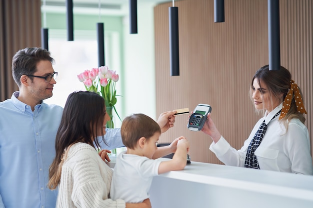 famiglia felice che fa il check-in in hotel