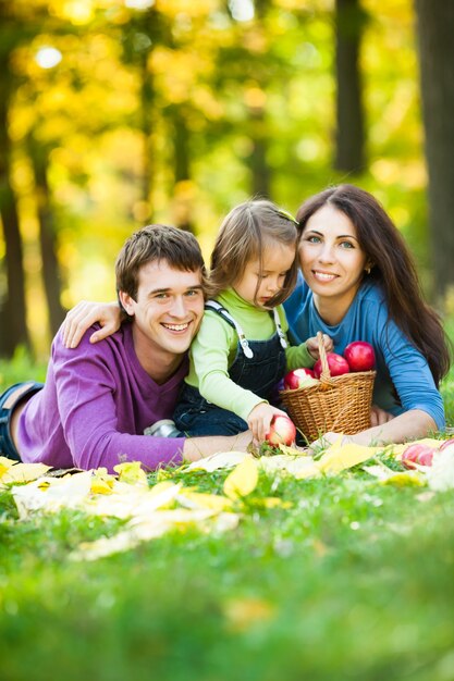 Famiglia felice che fa picnic sullo sfondo sfocato delle foglie autunnali