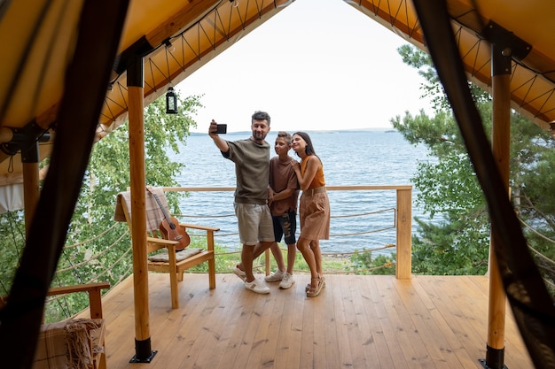 Famiglia felice che fa selfie in riva al mare nella località di villeggiatura estiva