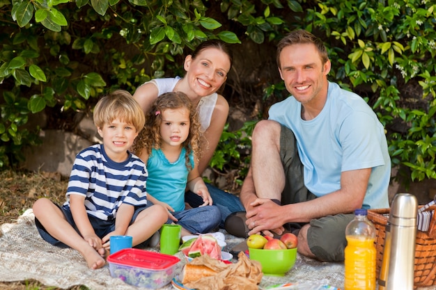 Famiglia felice che fa un picnic nel giardino