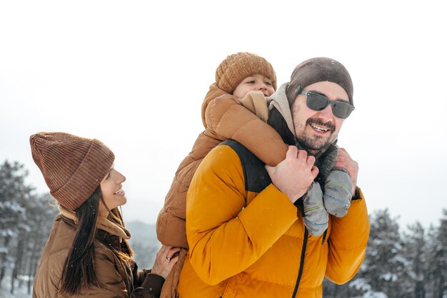 Famiglia felice che fa una passeggiata in inverno all'aperto nella neve