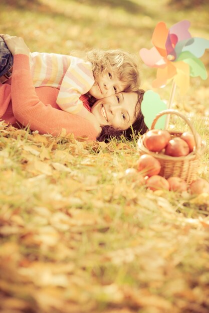 Famiglia felice che gioca all'aperto nel parco autunnale