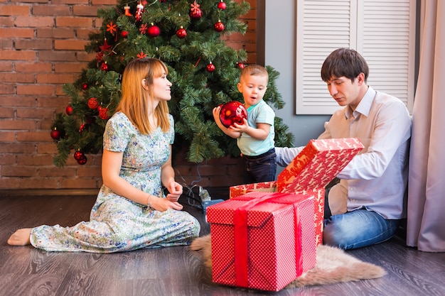 Famiglia felice che gioca con le palle di Natale a casa