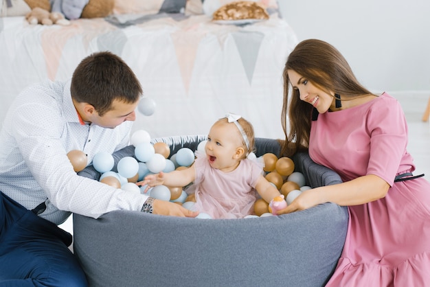 Famiglia felice che gioca con palloncini colorati nella stanza dei bambini a casa