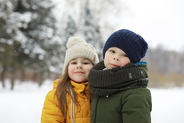 Famiglia felice che gioca e ride in inverno all'aperto nella neve. Giornata invernale del parco cittadino.