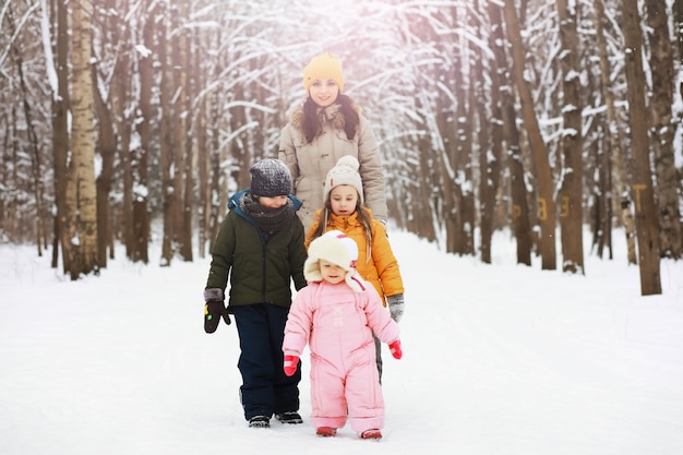 Famiglia felice che gioca e ride in inverno all'aperto nella neve. Giornata invernale del parco cittadino.