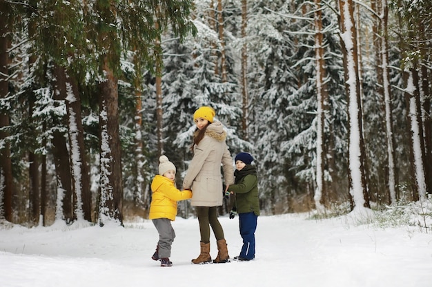 Famiglia felice che gioca e ride in inverno all'aperto nella neve. Giornata invernale del parco cittadino.