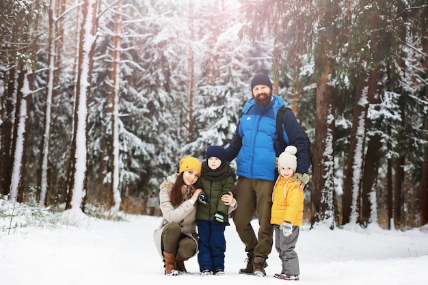 Famiglia felice che gioca e ride in inverno all'aperto nella neve. Giornata invernale del parco cittadino.