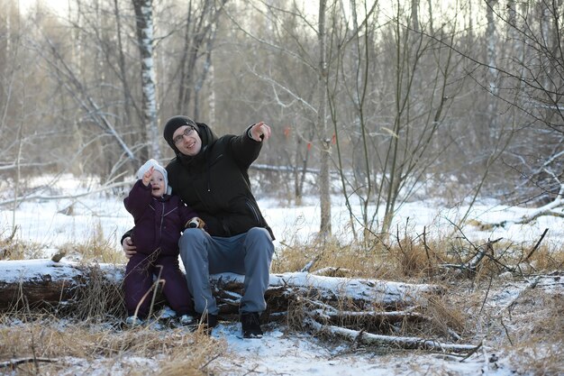 Famiglia felice che gioca e ride in inverno all'aperto nella neve. Giornata invernale del parco cittadino.