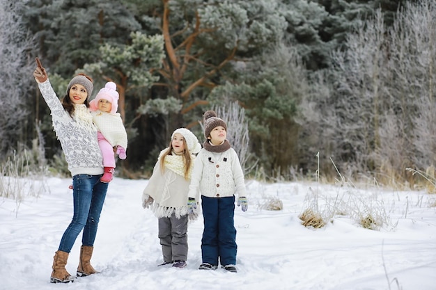 Famiglia felice che gioca e ride in inverno all'aperto nella neve. Giornata invernale del parco cittadino.