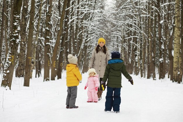 Famiglia felice che gioca e ride in inverno all'aperto nella neve. Giornata invernale del parco cittadino.