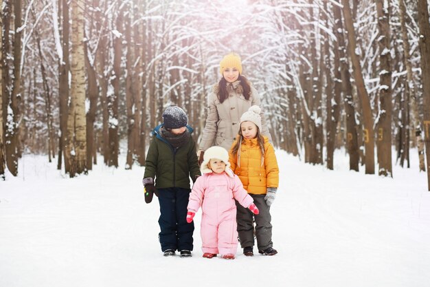 Famiglia felice che gioca e ride in inverno all'aperto nella neve. Giornata invernale del parco cittadino.